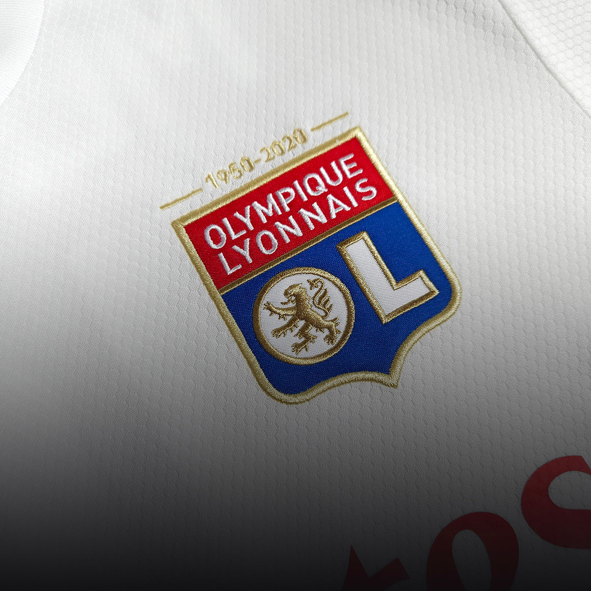 Close-up of the Olympique Lyon club badge on a white home football shirt